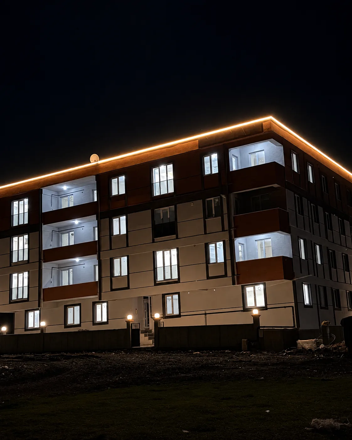 Elvin Apartmanı'nın saçak aydınlatmalı gece görünümü ve balkon cepheleri